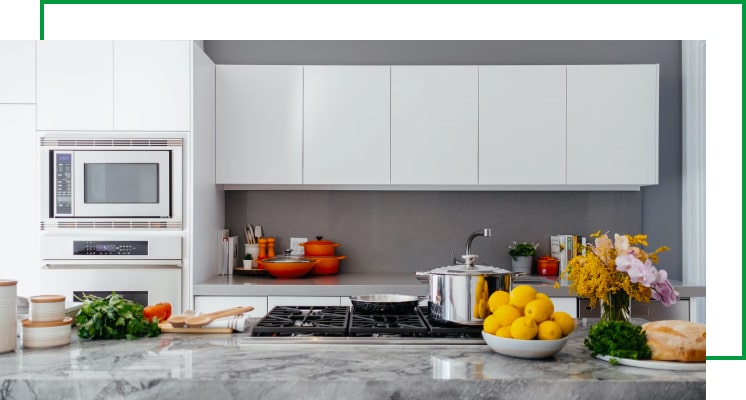 A modern kitchen with a vegetables on the bench and a clear space waiting for where the Thermomix will go